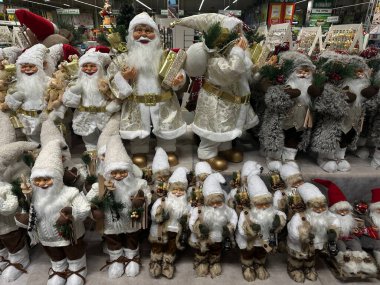 A cheerful Christmas display featuring Santa Claus figurines, gnomes, and owls with festive hats and holiday-themed decorations High quality photo