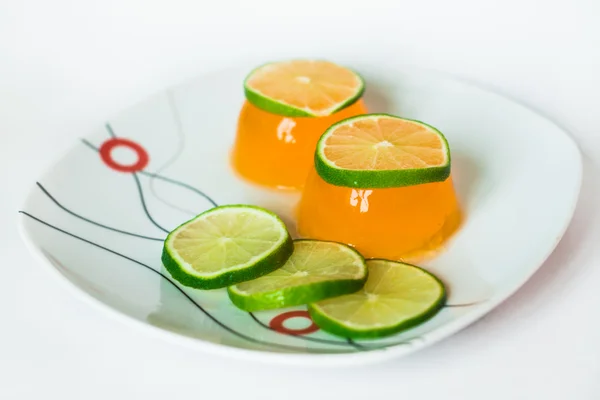 Orange jelly with slices lime on plate — Stock Photo, Image