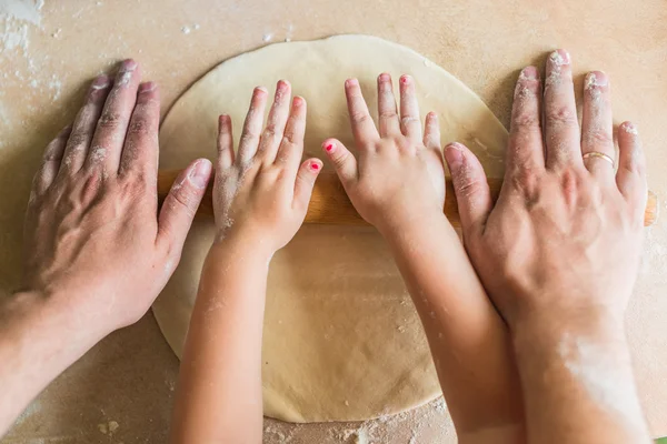 Children and dad hands rolled dough