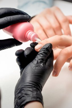 Manikürcüde genç bir kadın manikür yaparken tırnak yağıyla tırnak tedavisi.