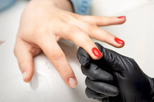 Jonge Vrouw Ontvangt Rode Nagel Lak Door Professionele Manicure Meester — Stockfoto