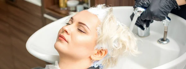 Fryzjerka Przygotowuje Się Zmycia Białego Barwnika Włosów Młodej Białej Kobiety — Zdjęcie stockowe