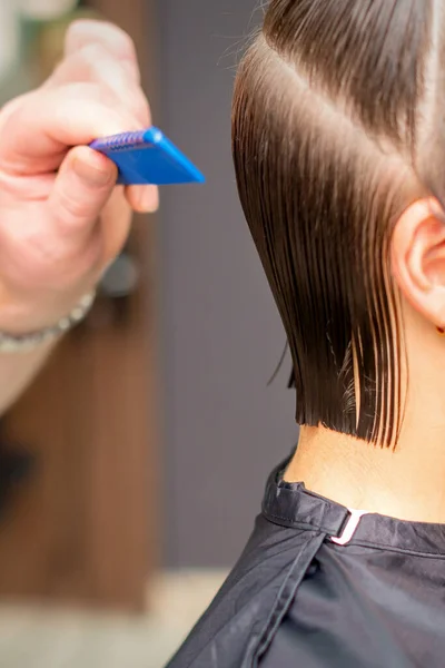 美容室で櫛で若い女の散髪を行う美容師の手の側面図 選択的焦点 — ストック写真