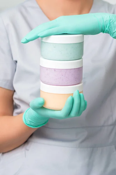 Drei Farbige Plastikdosen Den Händen Einer Kosmetikerin Mit Schutzhandschuhen — Stockfoto