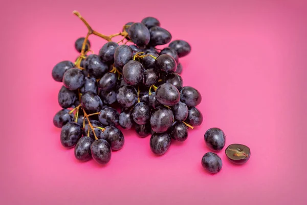 Von Oben Bund Reifer Schwarzer Trauben Auf Rosa Oberfläche — Stockfoto