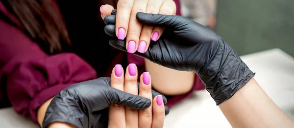 Handen Van Manicure Houdt Vrouwelijke Nagels Met Roze Nagellak Nagelsalon — Stockfoto