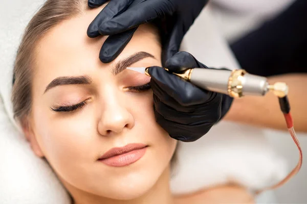 Beautician Applying Permanent Makeup Eyebrows Young Woman Special Tattoo Machine — Stock Photo, Image