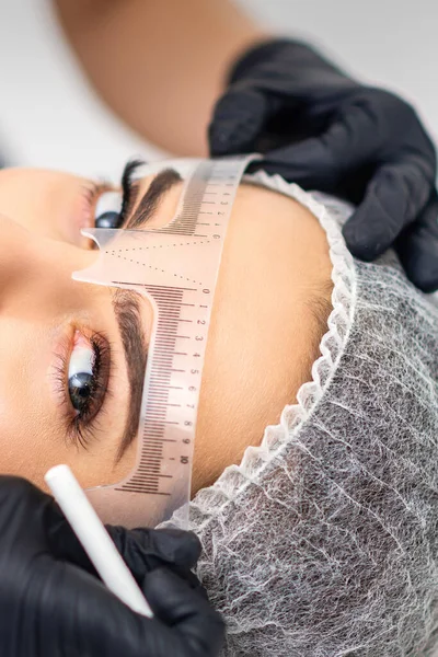 Cosmetólogo Está Midiendo Con Regla Las Cejas Joven Mujer Caucásica — Foto de Stock