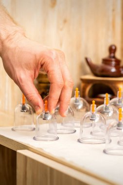 Masaj terapisti, kaplıcadaki bir masadan elektrikli cam kavanozları alır.