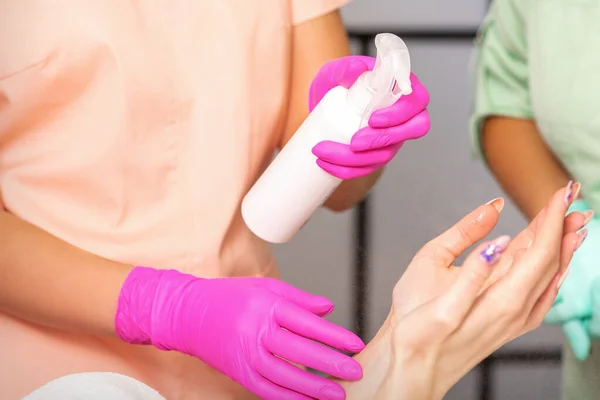 Kosmetička Gumových Ochranných Rukavicích Dezinfikuje Ruce Ženy Antiseptickým Sprejem Salonu — Stock fotografie