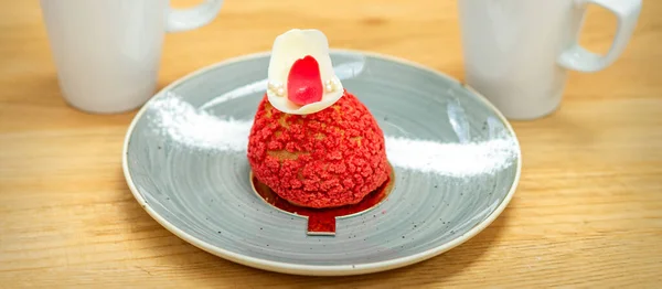 カフェでテーブルの上にラテをのせたプレート上の豪華な赤いデザートシューケーキ — ストック写真