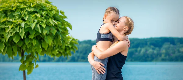 Mãe Abraçando Sua Filha Perto Lagoa Vestindo Roupas Esportivas Livre — Fotografia de Stock