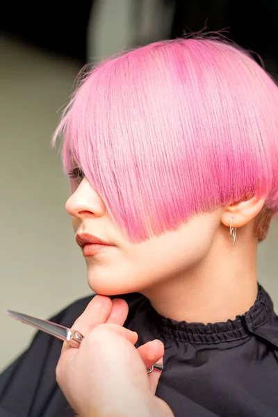 在美容院里 男性理发师为一位年轻的高加索女人做了短粉色的发型 — 图库照片