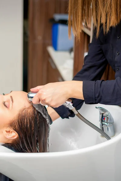 Kobieta Fryzjer Płucze Włosy Młodej Kobiety Zlewie Umyciu Włosów Salonie — Zdjęcie stockowe