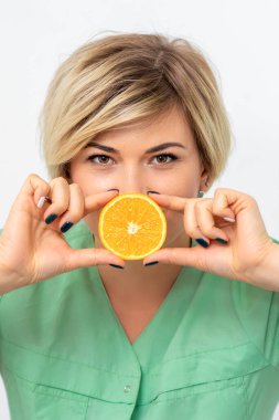 Diyet yapan kadın portresi ve beyaz arka planda dudaklarına bir dilim turuncu çizilmiş.