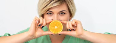 Diyet yapan kadın portresi ve beyaz arka planda dudaklarına bir dilim turuncu çizilmiş.