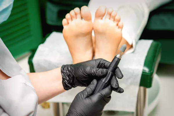 Chiropodist master prepares foot file machine before foot and toes clean treatment in a beauty salon