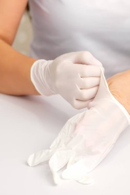 Hemşire ya da kadın doktorların ellerini kapatın. Masanın üzerine beyaz lastik koruyucu eldivenler giyin.