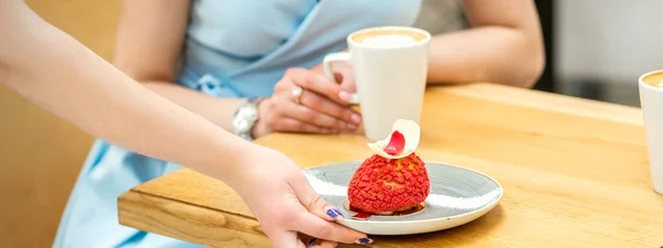 Mão Garçom Coloca Mesa Prato Com Cupcake Vermelho Fundo Uma — Fotografia de Stock