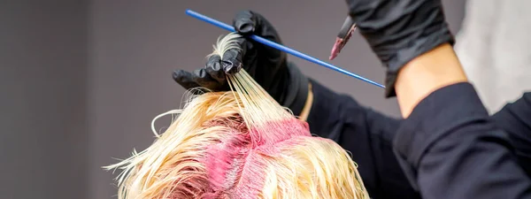 Close Mãos Cabeleireiro Aplicando Tinta Rosa Cabelo Loiro Mulher Salão — Fotografia de Stock