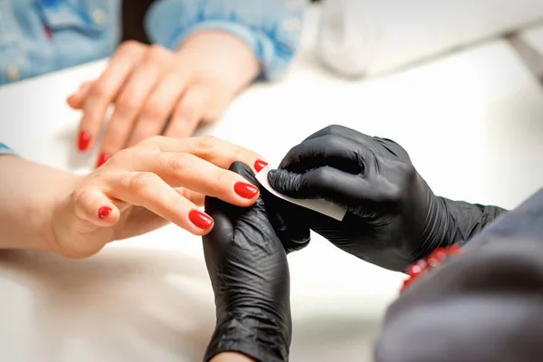 Close Van Manicure Meester Zwarte Handschoenen Vegen Vrouwelijke Rode Nagels — Stockfoto