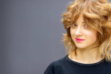 Koyu arkaplanda kırmızı kıvırcık saçlı güzel, beyaz bir kadın.