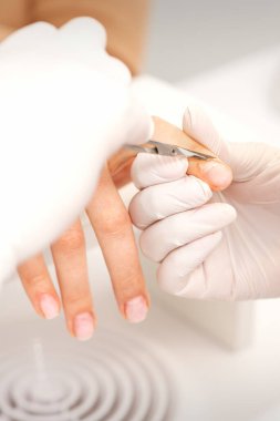 Manikür ustasına manikür makasıyla yaklaşmak güzellik salonundaki kadın tırnaklarının derisini yüzer.