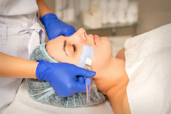 Kosmetyk Pokrywający Skórę Twarzy Kobiety Nawilżającą Maską Oczyszczającą Podczas Zabiegu — Zdjęcie stockowe