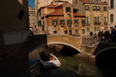 Tekneleri ve klasik duvarları olan Venedik kanalı