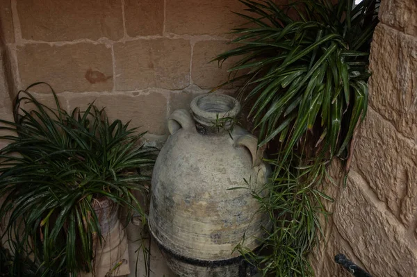 Old stone vase at the brick wall