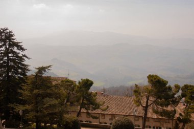 Tepeleri ve vadisi olan San Marino sisli manzarası