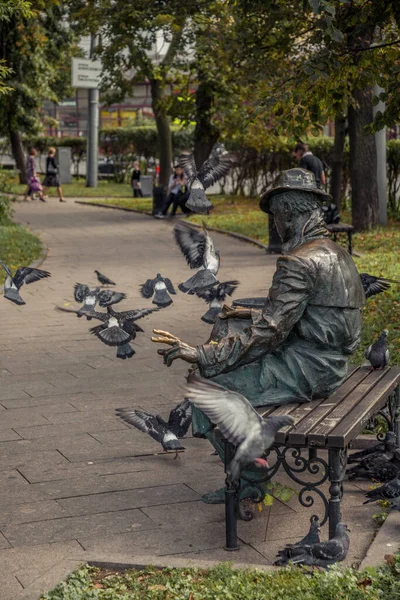 Eine Skulptur Sitzt Und Liest Mit Tauben Herum — Stockfoto