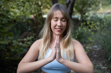 Doğal ortamında meditasyonla iç huzurunu ve sağlığını bulan bir kadın.