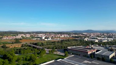 Güneş panelleri ve arka planda bir kasabanın yer aldığı endüstriyel bir alana sahip hava manzarası.