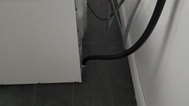 Kamera, çamaşır makinesine bağlı hortumları ve kabloları gösteriyor