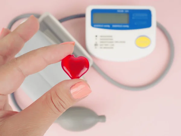 Stethoscope, heart shape, blood pressure monitor. female hand holding the heart, blood pressure.