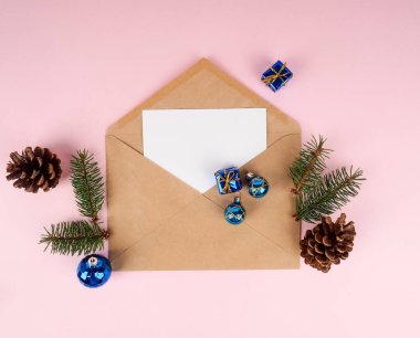 Zarfta Noel ağacı, en az yeni yıl kartı. Pembe arka planda ladin dalı. Tatiller, tebrikler konsept, mavi top.