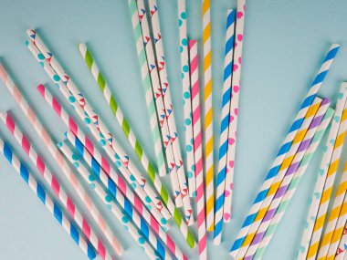 Kokteyller için bir grup karton tüp. Yaz kokteylleri için renkli, tek kullanımlık, çevre dostu pipetlerin üst görüntüsü. Yaz kokteylleri için renkli pipetler içmek.