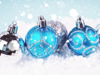 Mavi arka planda süslemesi olan mavi Noel topları.