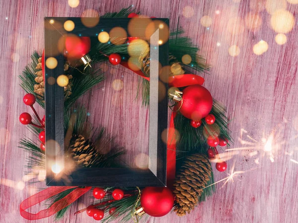 black wooden design frame and Christmas wreath next to it, new year concept on wooden old background.