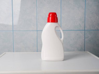 Çamaşır makinesinde bir şişe deterjan ve temiz havlu, mesaj için yer. Çamaşır günü.