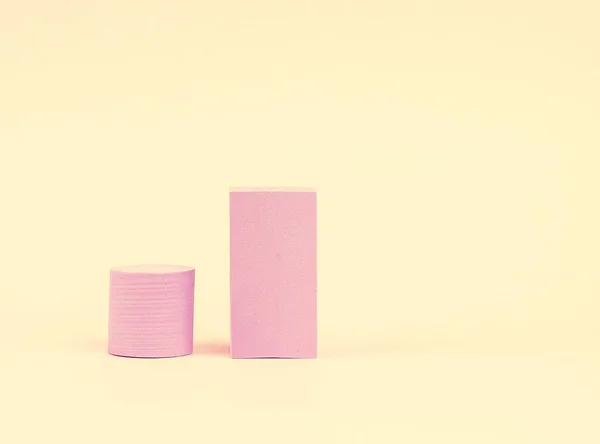 Stack of pink blocks. Geometrical figures still life composition. Platonic solids figures, simplicity concept photography. Pink rectangles and cylinders.