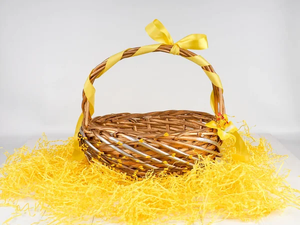 Wicker basket with yellow bow, empty straw basket — Stock Photo, Image