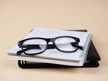 glasses on a black Notepad, stylish background. Copy space for your text.