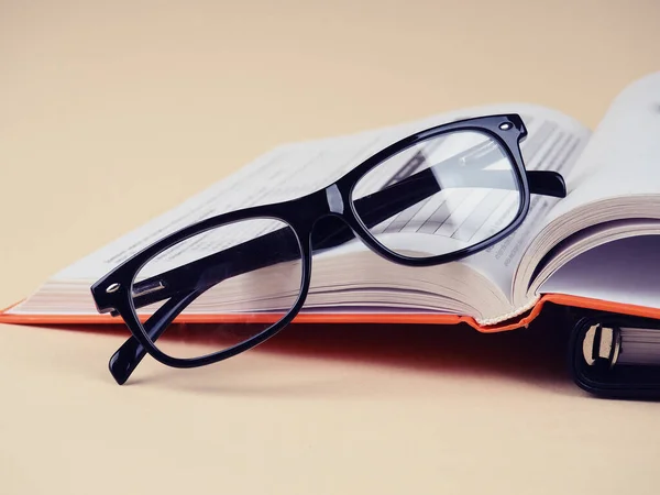 Glasses on a black Notepad, stylish background. Copy space for your text. 스톡 사진