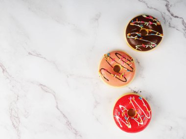 donuts in a row on a marble background, a copy of the space