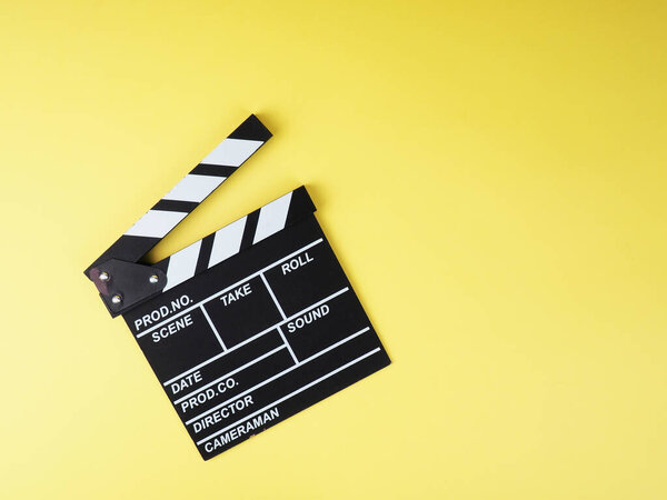 the concept of the film industry, a minimalistic composition on a yellow background with glasses and clapperboard. movies and cinema.