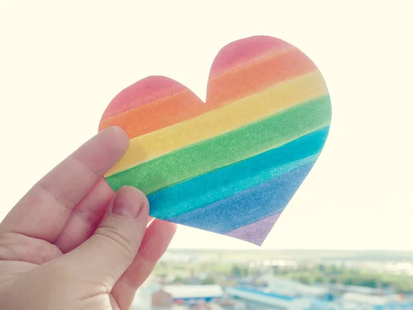 Rainbow Heart, lgbt rights koncept, handen håller ett hjärta målat som en hbt flagga, siluett mot solen — Stockfoto