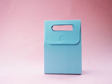 Pembe arka planda mavi boş hediye çantası, tasarımınız için.
