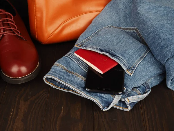 Мужской досуг, джинсы, кожаная обувь, паспорт и телефон, место для дизайна — стоковое фото